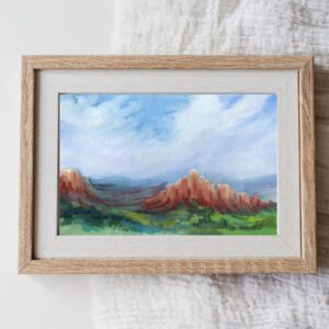 Christian desert landscape fine art print featuring red sandstone cliffs, green valleys, and expansive blue skies. Inspired by Isaiah 43:19 and titled "A Way in the Wilderness."