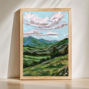 Fine art landscape print of rolling green mountains, wildflowers, and dramatic pink clouds beneath a blue sky. Inspired by Psalm 96:3 and titled "Declare His Glory."