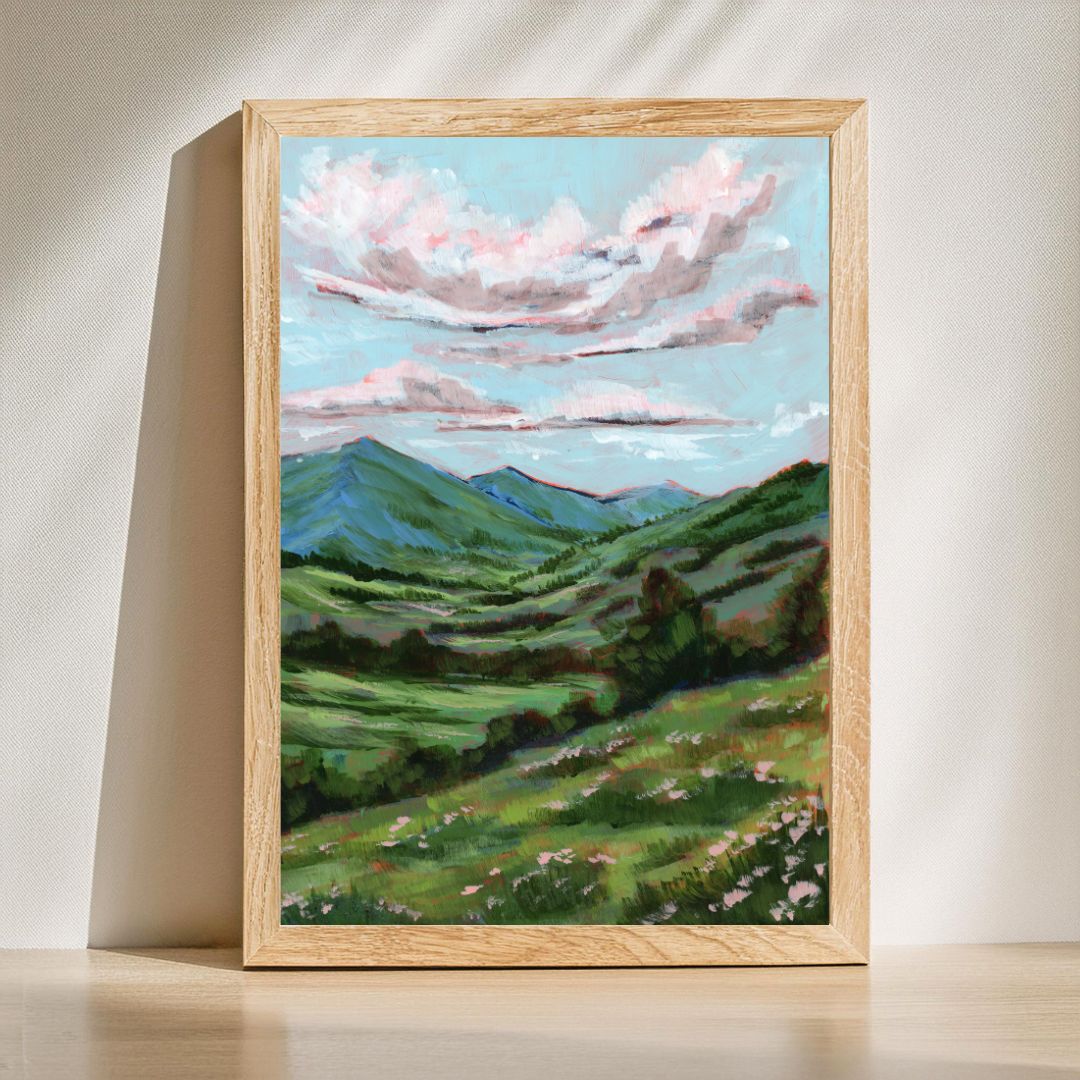 Fine art landscape print of rolling green mountains, wildflowers, and dramatic pink clouds beneath a blue sky. Inspired by Psalm 96:3 and titled "Declare His Glory."